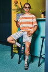 Person sitting on a stool wearing a striped shirt and shorts in a colorful room.
A pair of socks with a racing car design, featuring various cars with a start and finish line.
Sælar - sokkar Xpooos - bestu sokkarnir - sætir sokkar