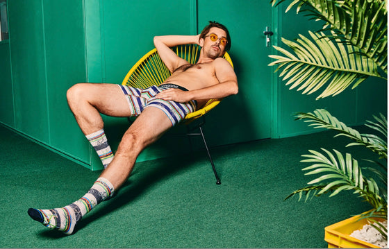 Man sitting on a chair wearing striped socks and underwear with a green wall and plant in the background.
Sælar - sokkar Xpooos - bestu sokkarnir - sætir sokkar